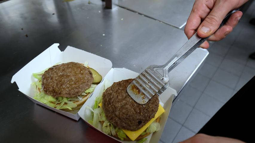 Die Handgriffe sitzen: Stück für Stück wird in Windeseile der Belag auf die Burger gestapelt.