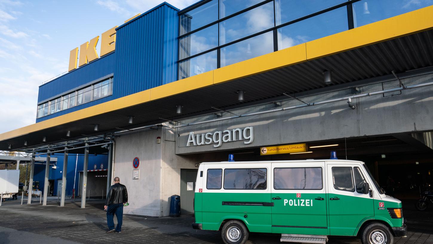 Ein Fahrzeug der Spurensicherung der Polizei steht vor einem Seiteneingang eines Ikea-Möbelhauses im Stadtteil Nieder-Eschbach, nachdem hier am Samstag ein Geldbote angeschossen und schwer verletzt worden war.