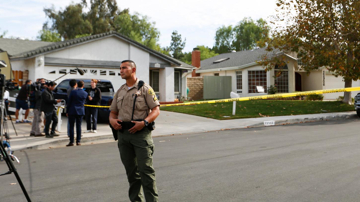 Ein Sheriff steht in der Nähe des Hauses des Verdächtigen, der an der Saugus High School mindestens zwei Menschen erschossen haben soll.