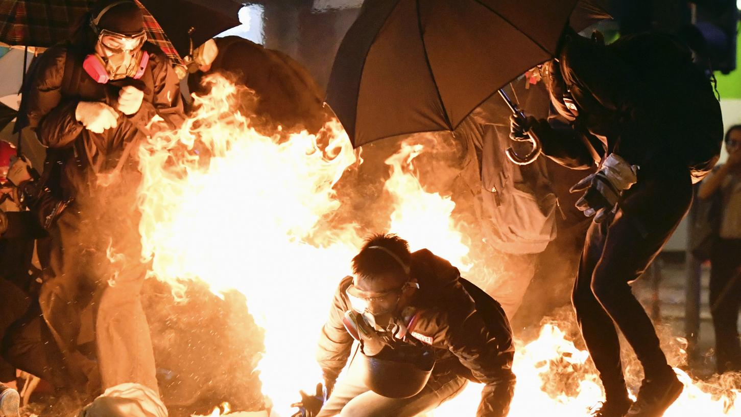 China, Hongkong: Ein Demonstrant versucht den Flammen eines geplatzten Molotowcocktaisl zu entkommen.