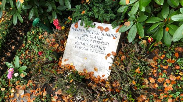 Helmut Schmidts letzter Weg führte nach Hamburg-Ohlsdorf. Dieser Friedhof ist einer der größten Europas. Man kann ihn als Besucher mit dem Auto befahren oder wahlweise eine der beiden vorhandenen Buslinien nehmen. Zu Fuß dauert es vom Eingangstor bis zum Ex-Kanzler fast eine halbe Stunde. Sein Name steht, Gipfel der Bescheidenheit, nicht mal auf dem eigentlichen Grabstein, denn dort waren alle verfügbaren Plätze bereits von Verwandten belegt. An Loki und Helmut Schmidt erinnert lediglich eine schlichte Steinplatte, die schräg auf der Erde liegt. Das Grab ist deswegen auf Anhieb gar nicht leicht zu finden.