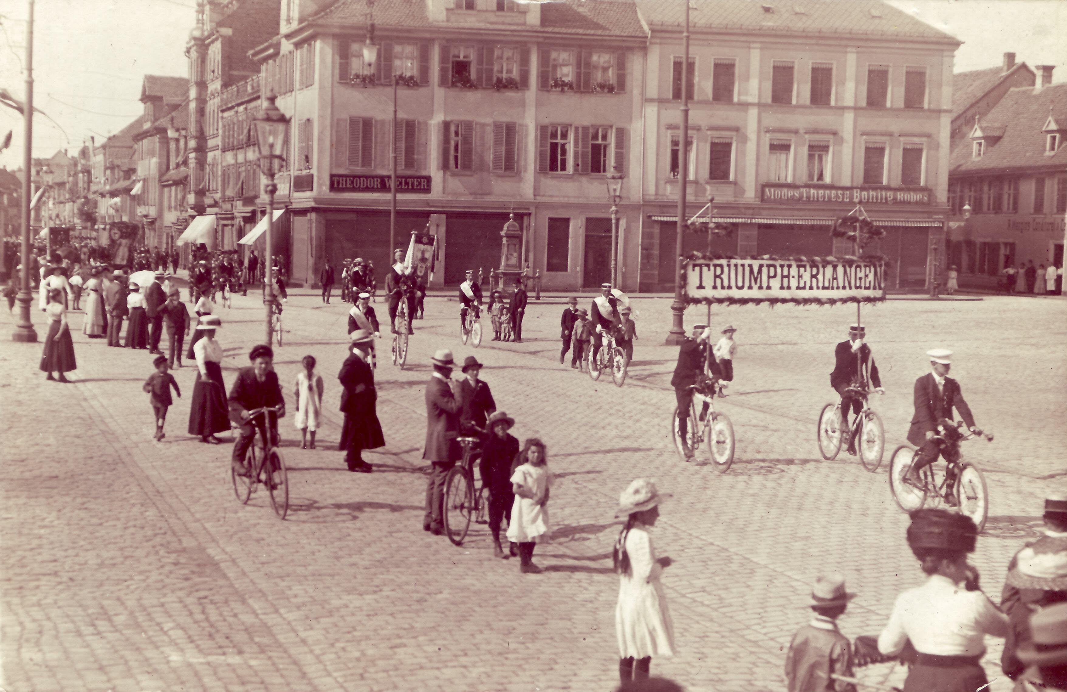 Umzug des Radler-Clubs „Triumph-Erlangen“ am Schlossplatz im August 1911. „Radfahren“ hat in der Hugenottenstadt eine lange Tradition. Schon 1884 haben sich die Erlanger Radfahrer in Vereinen zusammengeschlossen.