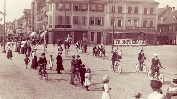 Umzug des Radler-Clubs „Triumph-Erlangen“ am Schlossplatz im August 1911. „Radfahren“ hat in der Hugenottenstadt eine lange Tradition. Schon 1884 haben sich die Erlanger Radfahrer in Vereinen zusammengeschlossen.