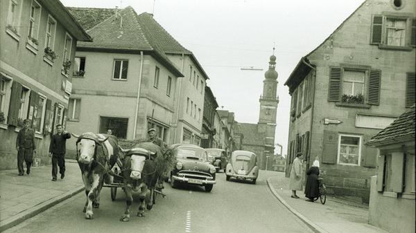 Die Aufnahme zeigt das noch vorhandene dörfliche Leben in der modernen Stadt der 1950er Jahre. Im Jahr 1957 - aus dem diese Aufnahme stammt - existierten noch 15 dörfliche Anwesen in der Innenstadt.
