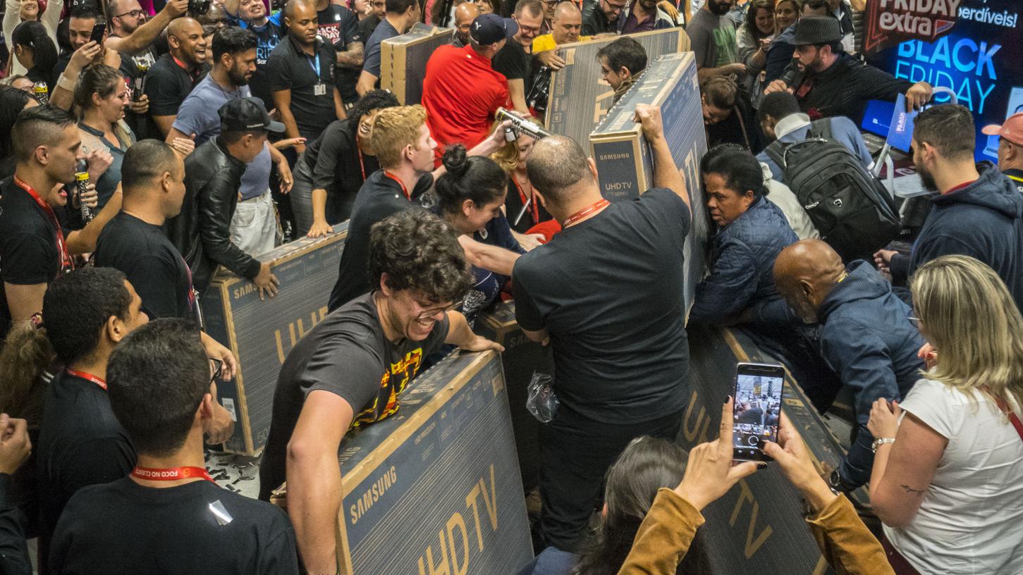 Käufer von Fernsehern versuchten am Black Friday in Sao Paolo ihre Geräte durch eine dichte Menschenmenge in einem Supermarkt nach draußen zu tragen.