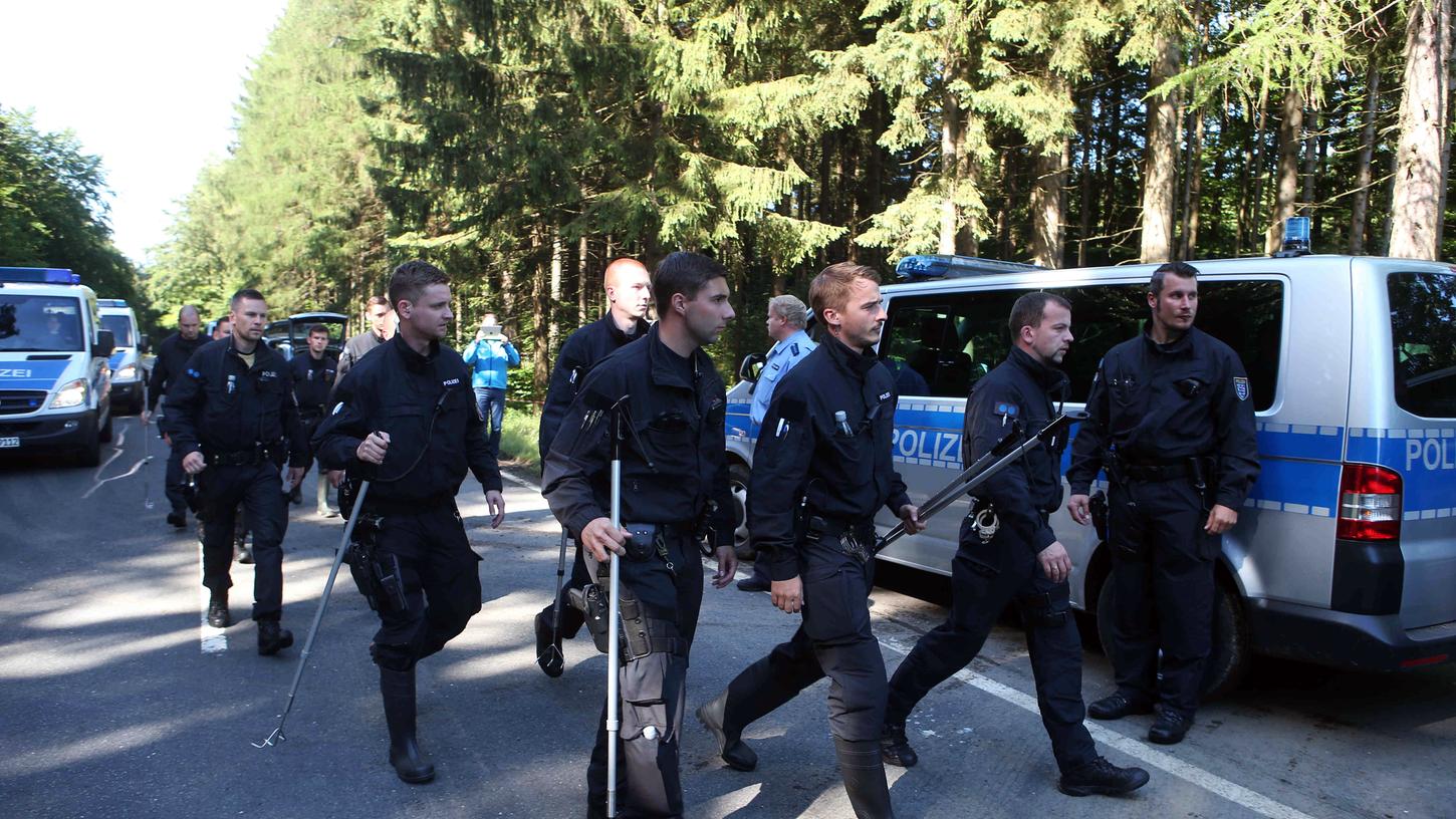 Polizeibeamte kämmen im Juli 2016 mit Suchstöcken ein Gebiet zwischen Bayern und Thüringen ab, nachdem ein Pilzsammler dort im Wald die sterblichen Überreste der kleinen Peggy entdeckt hat, rund 20 Kilometer von Lichtenberg entfernt.