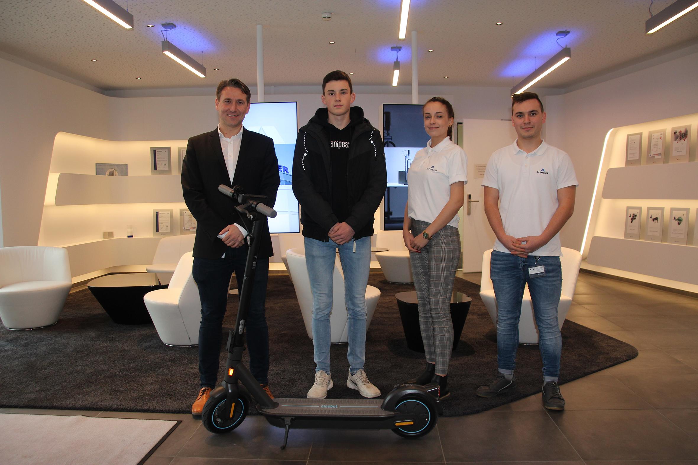 Die Alfmeier Gruppe präsentierte sich in der Stadthalle Treuchtlingen auf der BAM 2019. Die zahlreichen Besucher konnten sich aus erster Hand zu den verschiedenen Berufen informieren, die am Standort Treuchtlingen ausgebildet werden. Auch in diesem Jahr veranstaltete Alfmeier ein firmeneigenes Gewinnspiel. Zu gewinnen gab es in diesem Jahr einen E-Scooter der Marke Segway mit freundlicher Unterstützung von Velovita Rad. Sport. aus Weißenburg. Der E-Scooter konnte vor Ort in einem kleinen Parcours probe gefahren werden. Insgesamt 53 Besucher nahmen am Gewinnspiel teil. Voraussetzung für die Teilnahme in diesem Jahr war es, ein paar Fragen zu einem von den Auszubildenden selbst gedrehten Filmclip zu verschiedenen Ausbildungsberufen zu beantworten. Am Nachmittag war es dann soweit und der Gewinner – Tim Rachinger – wurde ausgelost. Im Namen der Alfmeier Präzision SE übereichte Alexander Bilinski, Leitung der nichtakademischen Ausbildungsprogramme, den außergewöhnlichen Gewinn an Herrn Rachinger und wünschte ihm viel Spaß und allseits gute Fahrt mit seinem neuen E-Scooter. Auf dem Foto sind von links: Alexander Bilinski (HR Referent), Tim Rachinger (Gewinner), Sabrina Wargel (Auszubildende zur Industriekauffrau), Max Hussendörfer (Auszubildender zum Industriekaufmann).