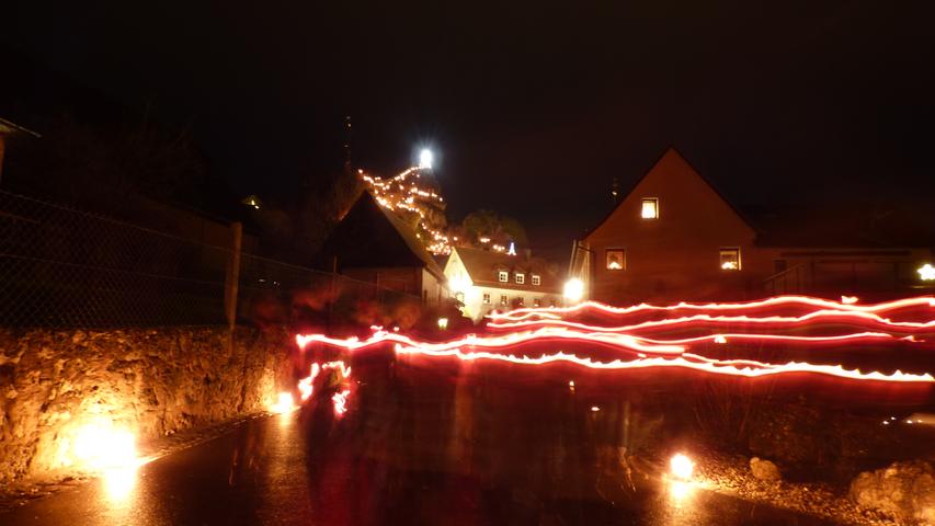 Die rund 1000 Wachslichter an den Straßenrändern entlang des Prozessionswegs und auf dem Wahrzeichen des Gößweinsteiner Ortsteils, dem Wichsenstein, tauchten das Jurahochdorf dabei in einen romantischen Lichterschein.