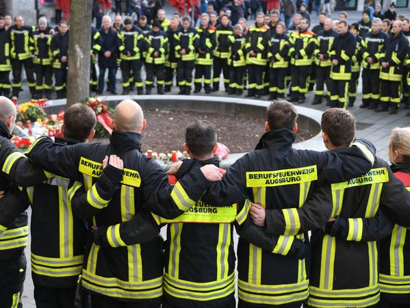 Am Königsplatz in Augsburg trauern Feuerwehrmänner um ihren Kameraden.