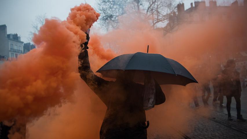 Ein Demonstrant hält in Nantes einen Kanister mit farbigem Rauch in der Hand: Hunderttausende Menschen gingen sechs Tage lang in ganz Frankreich auf die Straße, um gegen die Pläne der Regierung, das Rentensystem zu überarbeiten, zu streiken.  Am Rande der Proteste kam es vor allem in der Hauptstadt Paris zu Ausschreitungen.