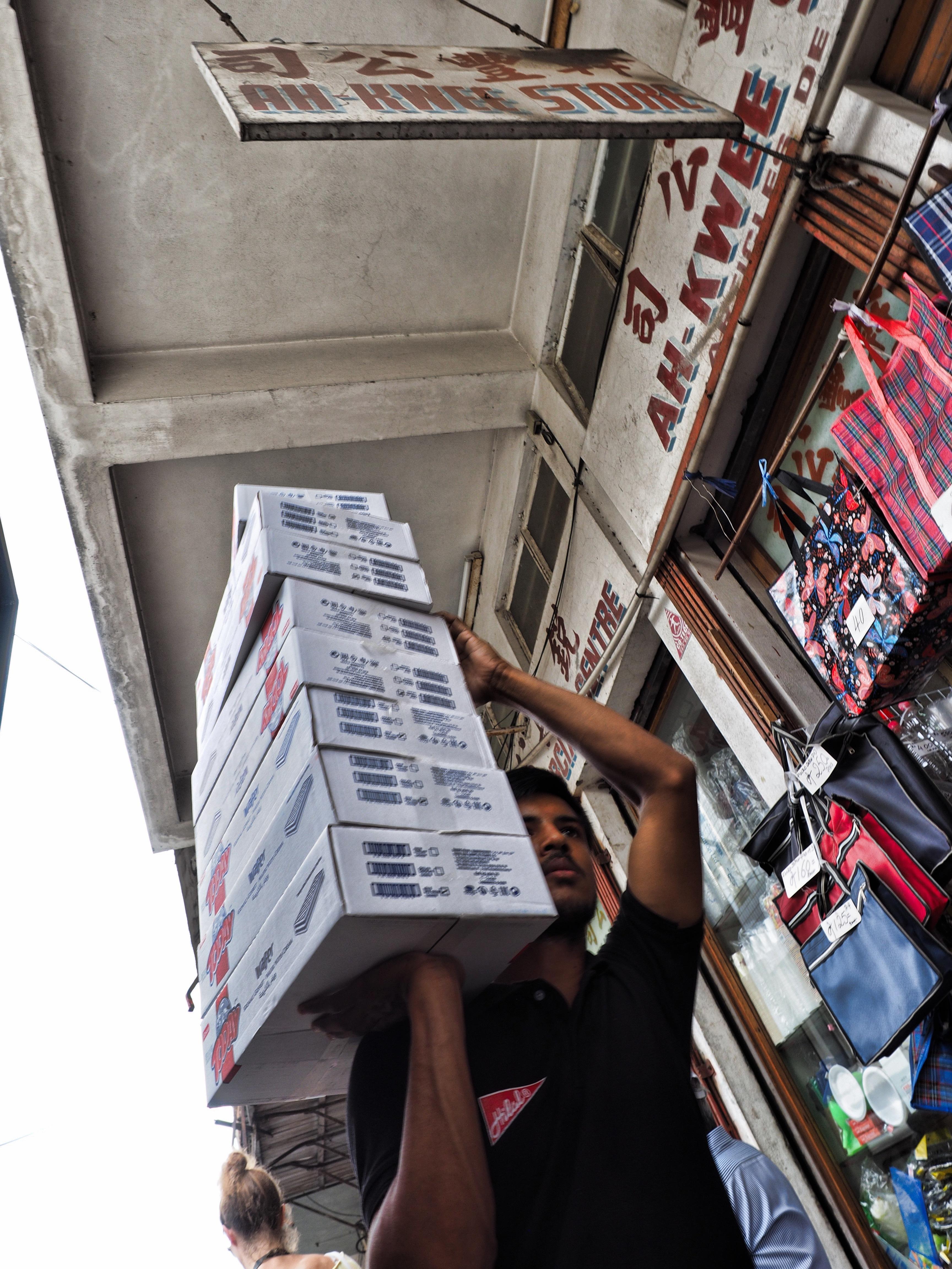 Ein Träger bringt Ware in einen Laden.