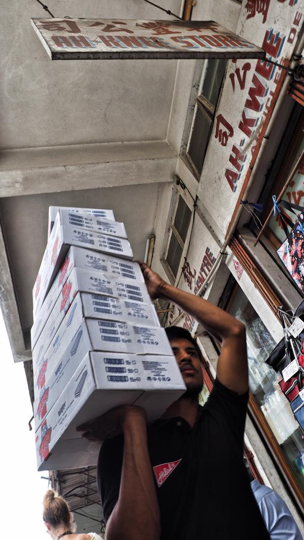 Ein Träger bringt Ware in einen Laden.