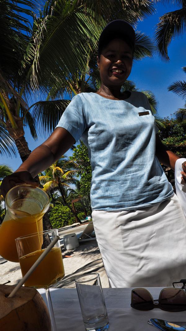 Danach schenkt eine Kellnerin frisch gepressten Orangensaft zum Frühstück ein.