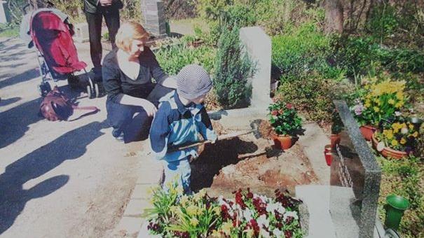Kerstins Sohn Jonas schaufelt Erde auf das frische Grab seiner Schwester Lara.