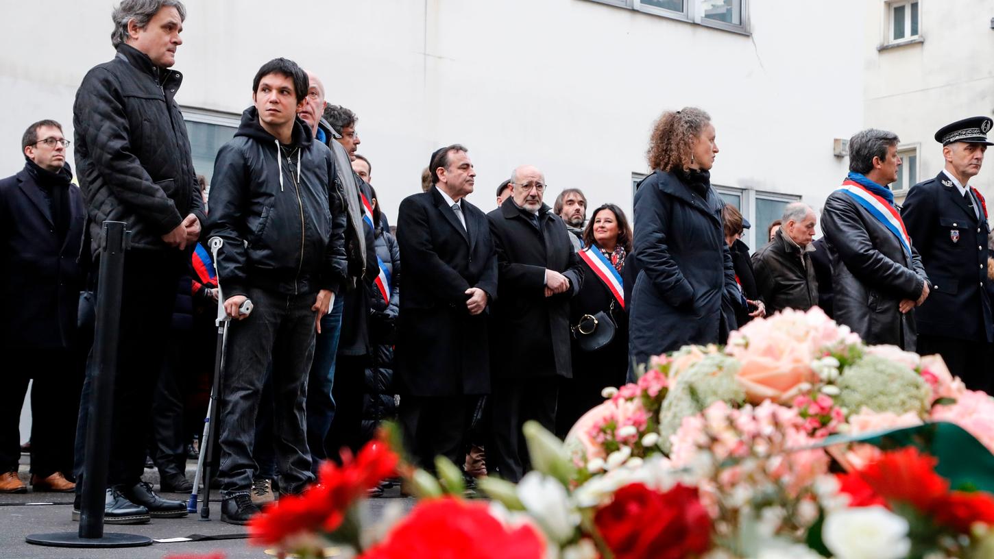 Herausgeber und Karikaturist Laurent Sourisseau (links) gedenkt bei der Trauerveranstaltung vor der ehemaligen Redaktion von Charlie Hebdo in Paris an seine getöteten Kollegen.