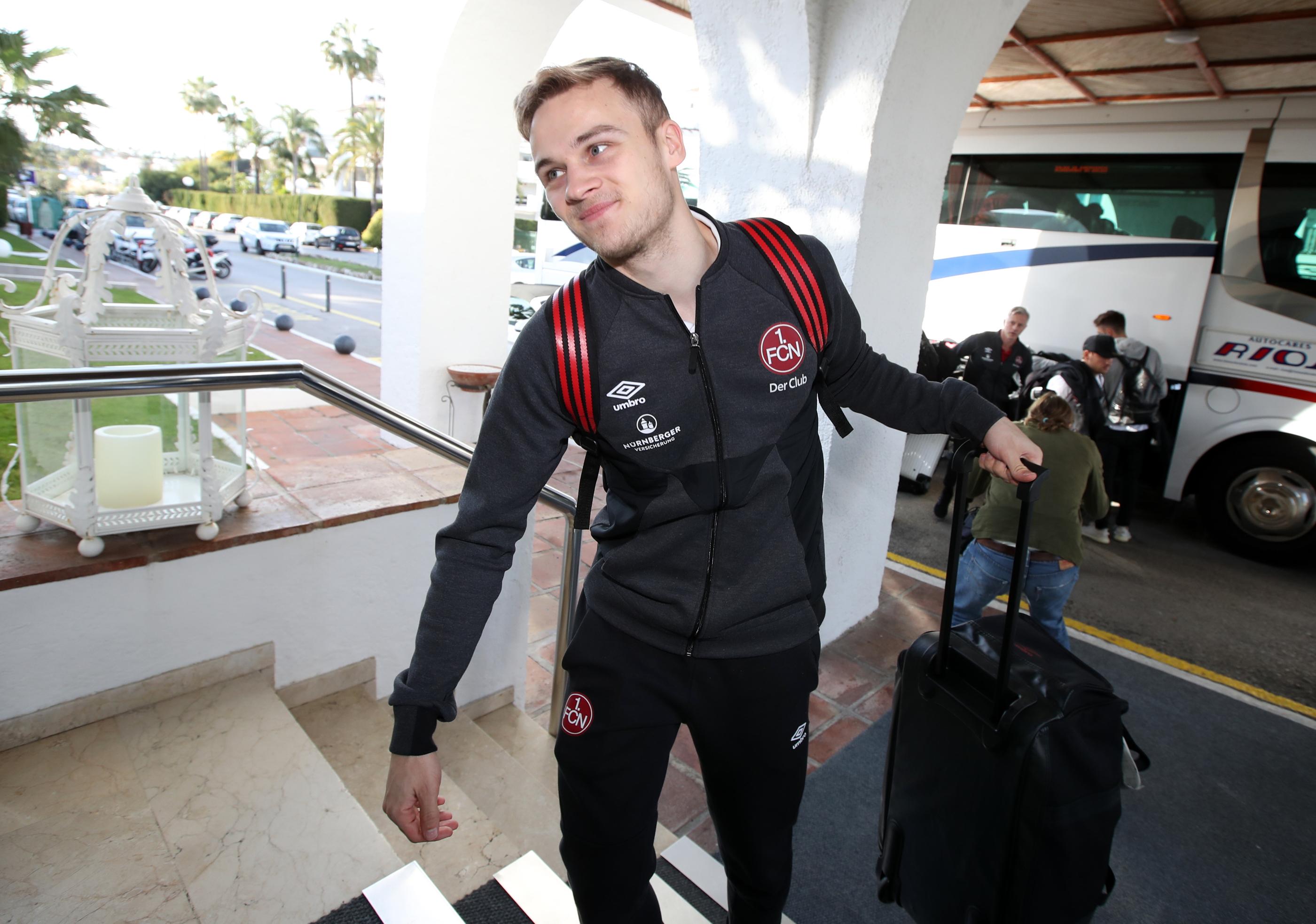 Tim Handwerker hebt mit einem fast schon erleichterten Gesichtsausdruck seinen Koffer die Stufen zum Hotel hoch. Die Spieler sind in ihrem Zuhause für die nächsten zehn Tage angekommen.