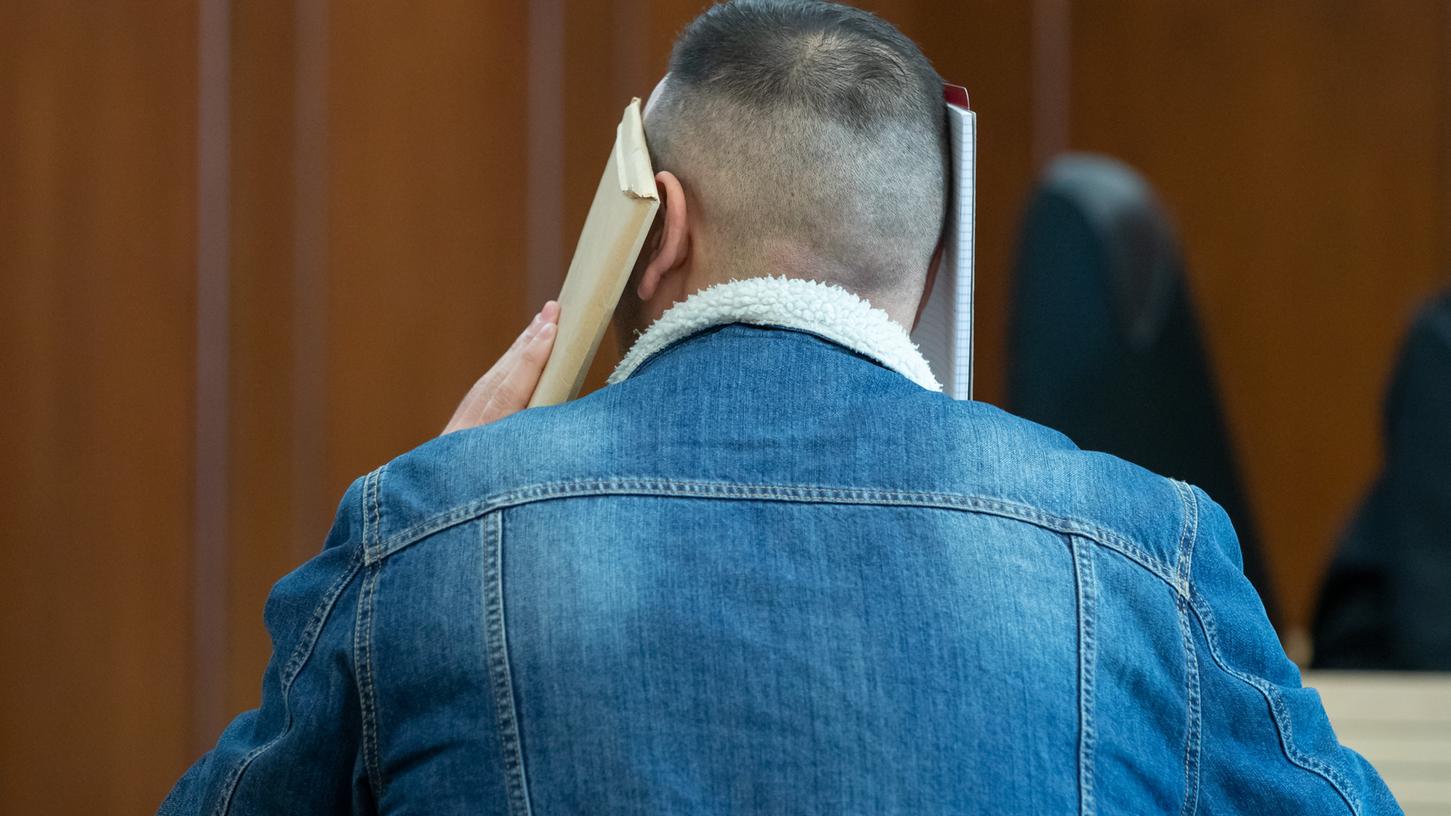 Ein junger Mann sitzt vor Verhandlungsbeginn im Sitzungssaal im Oberlandesgericht Nürnberg. Der 24-Jährige soll einen Auftragsmörder angeheuert haben, der seine 16-jährige Schwester töten sollte, weil sie eine Zwangsheirat verweigert hatte.