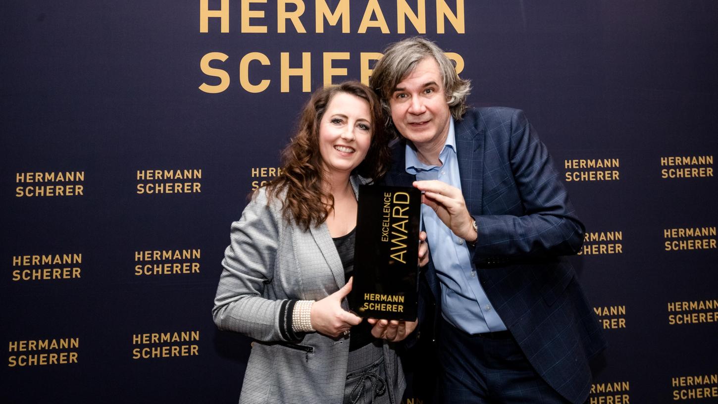 Melanie Ebert aus Willersdorf im Landkreis Forchheim hält den Excellence Award, überreicht von Hermann Scherer, in den Händen.