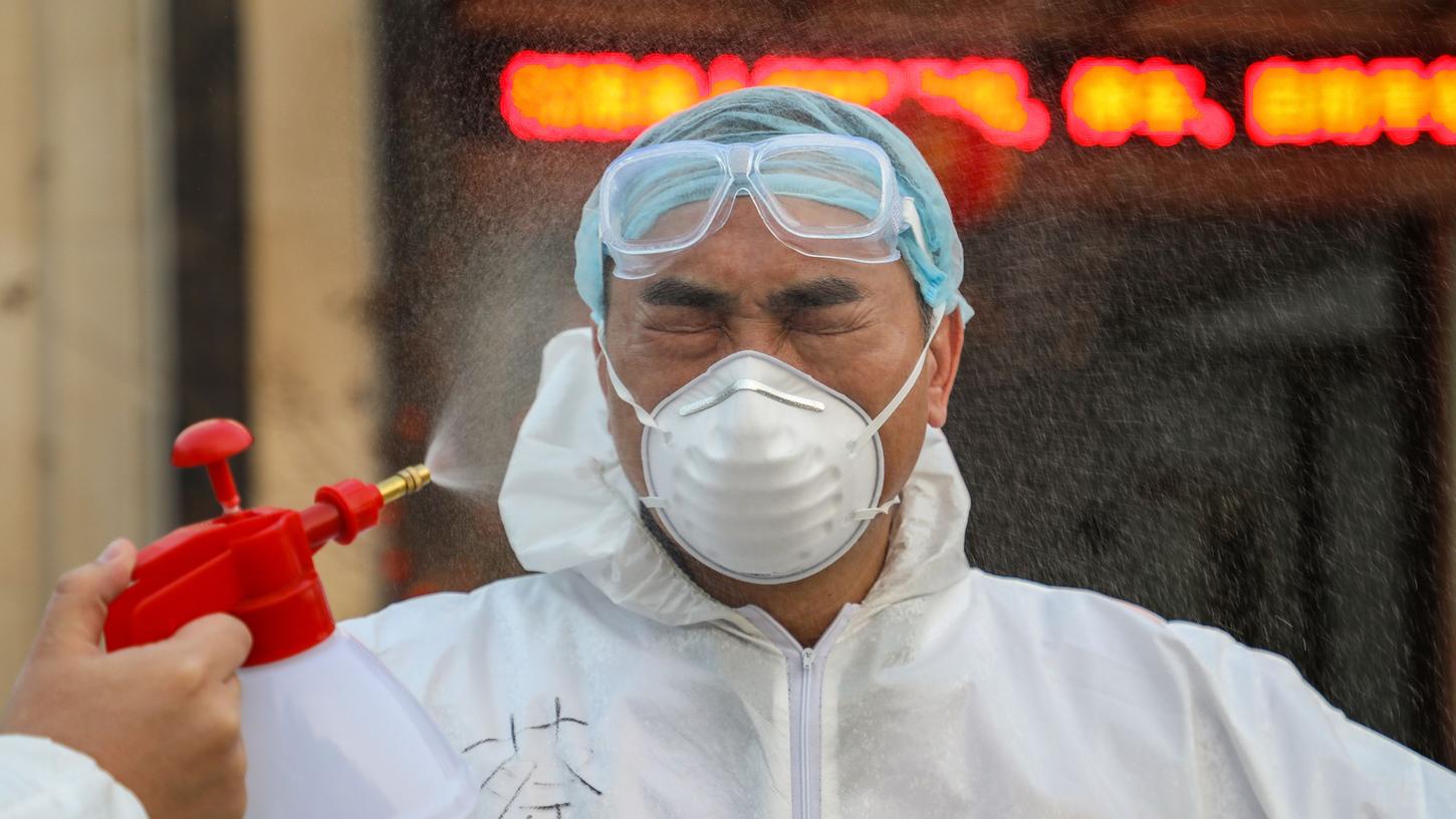 Ein Arzt wird nach der Behandlung in einer Quarantänezone in Wuhan von einem Kollegen desinfiziert, nachdem er dort Infizierte behandelt hatte.