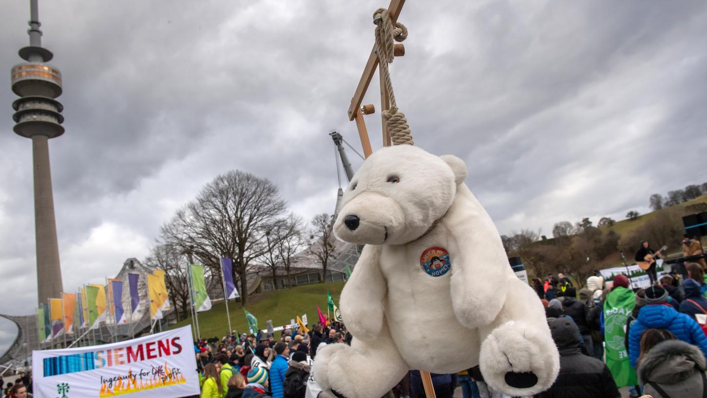 Ein Stoff-Eisbär hängt während einer Kundgebung am Rande der Siemens-Hauptversammlung 2020 vor Olympiahalle an einem Galgen, den Klimawandel symbolisierend.
