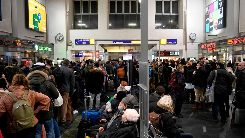 Passengers wait at the main railway station because of the forecasted heavy storm 'Sabine' in Dortmund, western Germany on February 9, 2020. - Germany hunkered down Sunday for a powerful storm expected to disrupt air, rail and sea links, cancel sports events, cut electrical power and damage property. With howling winds and driving rain, forecasters said Ciara would also hit France, Belgium, the Netherlands, Switzerland and Britain. (Photo by Ina FASSBENDER / AFP)