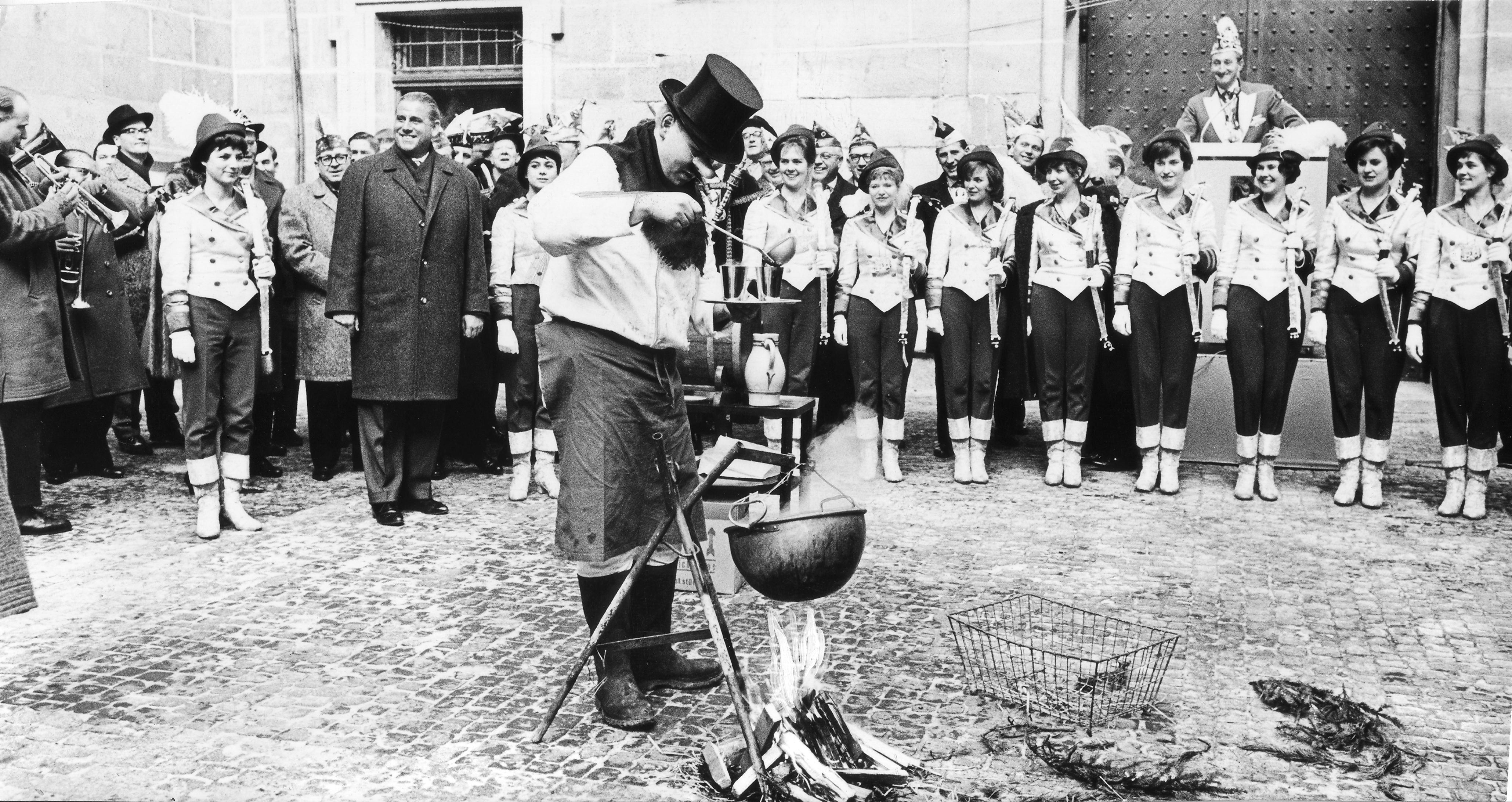 Glühwein, über offenem Lagerfeuer zubereitet, wird vom Knoblauchsländer-Chefkoch in Becher für den Oberbürgermeister Andreas Urschlechter abgefüllt.