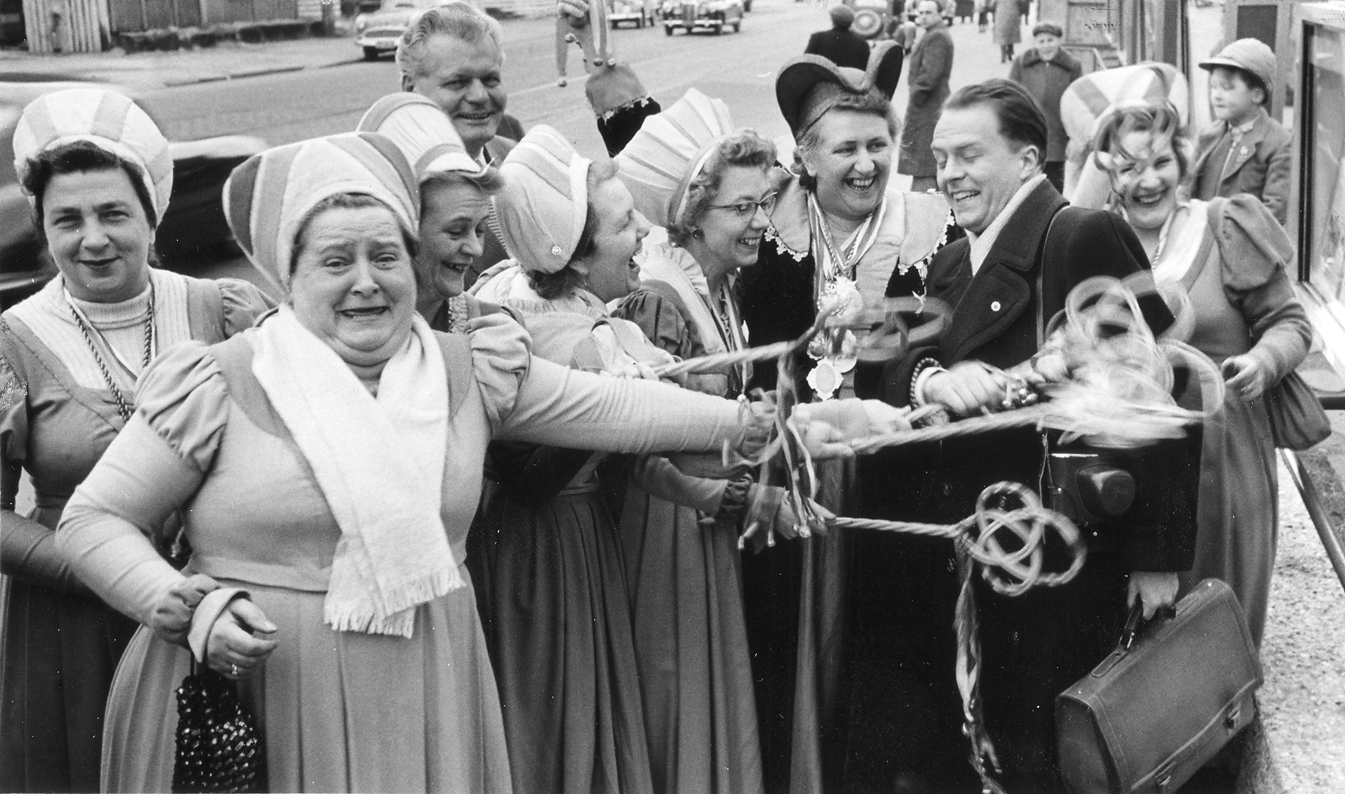 Dieser zum Fasching 1957 veröffentlichte Schnappschuss trug diese Bildunterschrift: "Harmlos studierte dieser Mann die Zeitungen in den Aushangkästen vor dem Gebäude der Nürnberger Nachrichten am Marienplatz, als die weibliche "Meute" über ihn herfiel. Von allen Seiten -man sieht es ganz deutlich- bekommt er seine "Haue"."