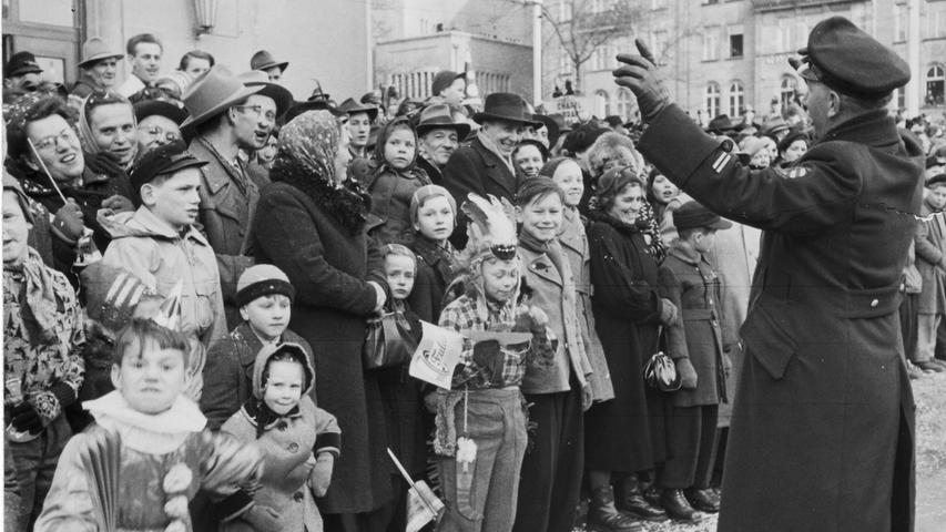 Ordnung muss sein: beim Faschingszug 1953 dirigiert ein Polizist die Menschenmenge am Straßenrand.
