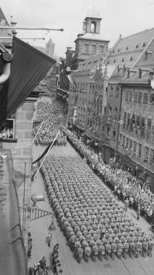 Bei den Reichsparteitagen nutzte die NSDAP die Kulisse der historischen Nürnberger Altstadt. Hier ein Aufmarsch vom Hauptmarkt am Rathaus vorbei in Richtung Kaiserburg.