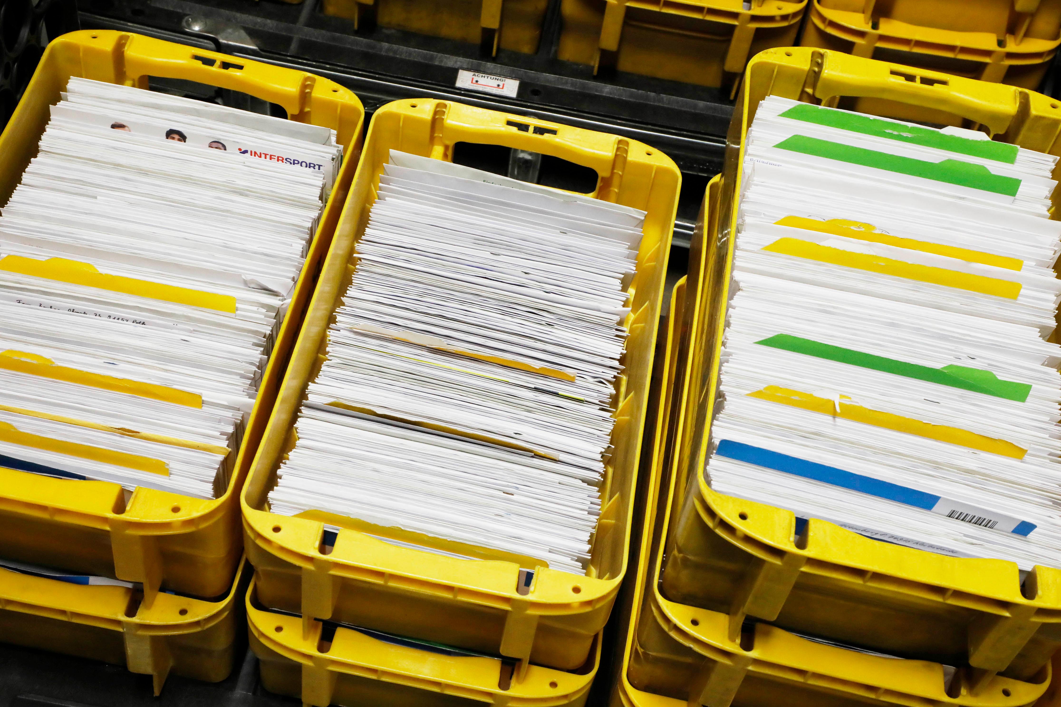 Die Post kommt vorsortiert in gelben Boxen an. Sie läuft im Briefzentrum durch die Maschine, die mit ihrer Software die Briefe in der Reihenfolge anordnet, wie der Postbote sie später austrägt.