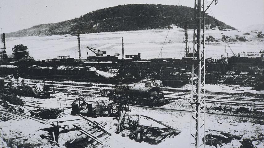 Auf fast jedem Gleis des Treuchtlinger Bahnhofs treffen die US-Bomber am 23. Februar 1945 Güter- und Personenzüge. Das Bild zeigt die Zerstörungen unweit des Bahnbetriebswerks mit dem Nagelberg im Hintergrund.