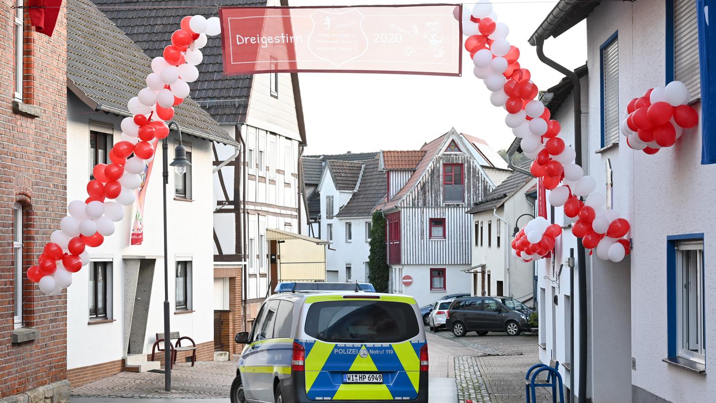 Ein Polizeiauto fährt in Volkmarsen unter einer Girlande mit Luftballons durch. Hier war am Rosenmontag ein Mann mit seinem Auto in die Menschenmenge gerast.