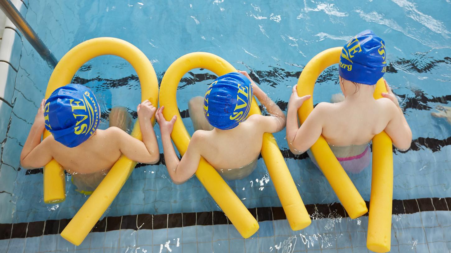  Kinder sitzen beim Schwimmunterricht im Wasser. Die Deutsche Lebensrettungsgesellschaft (DLRG) rechnet wegen corona-bedingt geschlossener Schwimmbäder damit, dass sich der Anteil von Kindern und Jugendlichen, die nicht schwimmen können, weiter erhöht.