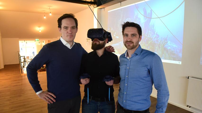 Für den Fotografen hat Café-Leiter Peter Schwachhofer die VR-Brille aufgesetzt, eingerahmt wird er von Marlon Hassel (links) und Clemens Orendt, zwei der drei Macher des Pixels.