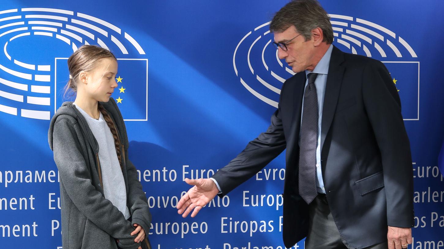 David Sassoli (r), Präsident des Europäischen Parlaments, streckt Greta Thunberg, Klimaaktivistin aus Schweden, vor einer Sitzung des Umweltrates im Europäischen Parlament die Hand entgegen.