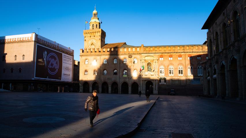 Nur wenige Menschen haben sich auf die Piazza Maggiore in Bologna verirrt. Die italienische Regierung hat im Zuge der Ausbreitung des Coronavirus die Bewegungsfreiheit der Bürger stark eingeschränkt.