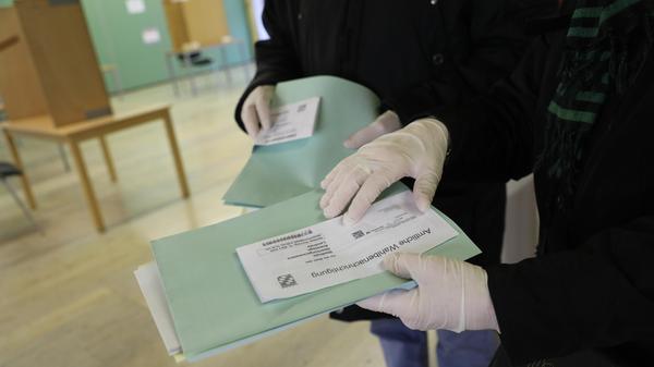 Die Auswirkungen des Corona-Virus auf die Wahlen: Zum Teil trugen Wahlhelfer Mundschutz, Einmalhandschuhe, in den Wahllokalen stand Desinfektionsspray zur Verfügung; Wähler konnten ihren eigenen Kugelschreiber mitbringen.