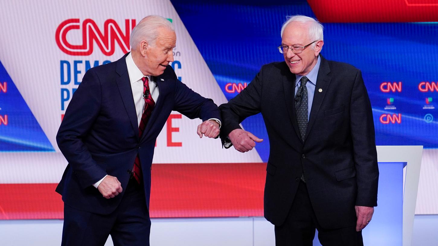 Anstatt Hände zu schütteln, stießen sich Biden und Sanders die Ellenbogen aneinander.