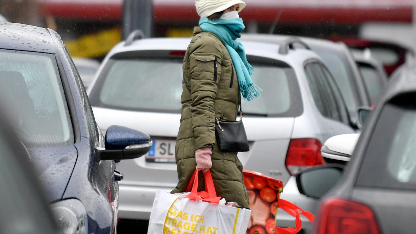 13.03.2020, Ãsterreich, Salzburg: Eine Frau mit Mundschutz trägt ihre Einkäufe über den Parkplatz eines Einkaufszentrums. Im Kampf gegen das Coronavirus müssen in Ãsterreich ab kommender Woche viele Geschäfte vorübergehend schlieÃen. Lebensmittelmärkte und Apotheken dürfen weiterhin offen bleiben, sagte Bundeskanzler Kurz am Freitag in Wien. Foto: Barbara Gindl/APA/dpa +++ dpa-Bildfunk +++ 13.03.2020, Ãsterreich, Salzburg: Eine Frau mit Mundschutz trägt ihre Einkäufe über den Parkplatz eines Einkaufszentrums. Im Kampf gegen das Coronavirus müssen in Ãsterreich ab kommender Woche viele Geschäfte vorübergehend schlieÃen. Lebensmittelmärkte und Apotheken dürfen weiterhin offen bleiben, sagte Bundeskanzler Kurz am Freitag in Wien. Foto: Barbara Gindl/APA/dpa +++ dpa-Bildfunk +++