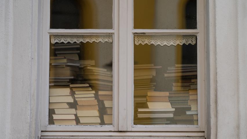 19.03.2020, Bayern, Mitterteich: In der Bücherei sind zahlreiche Bücher durch ein Fenster zu sehen. Das Landratsamt in Tirschenreuth erteilte am Mittwochabend eine Ausgangssperre, weil in Mitterteich die Zahl der am Coronavirus erkrankten Menschen besonders hoch ist. Foto: Nicolas Armer/dpa +++ dpa-Bildfunk +++