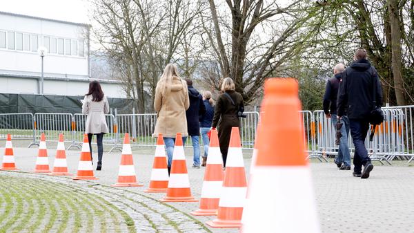 Direkt an der überdachten Abstrich-Station arbeiten in einem angrenzenden Container zwei Kräfte des Bayerischen Roten Kreuzes.