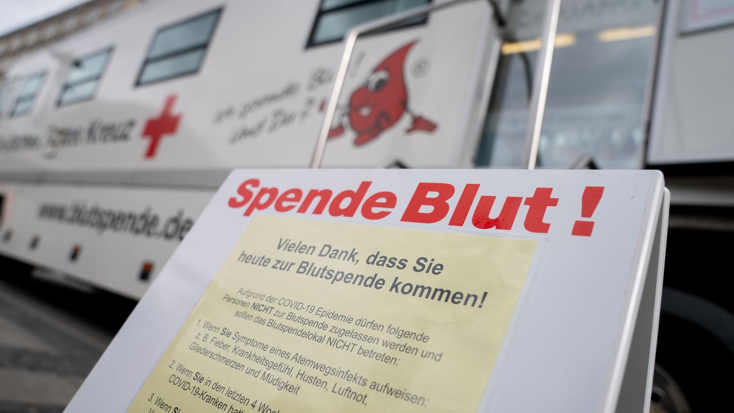 "Spende Blut" - auch am Berliner Alexanderplatz können sich Freiwillige im Blutspende-Bus melden. Ein Plakat klärt ebenfalls über das Coronavirus auf.