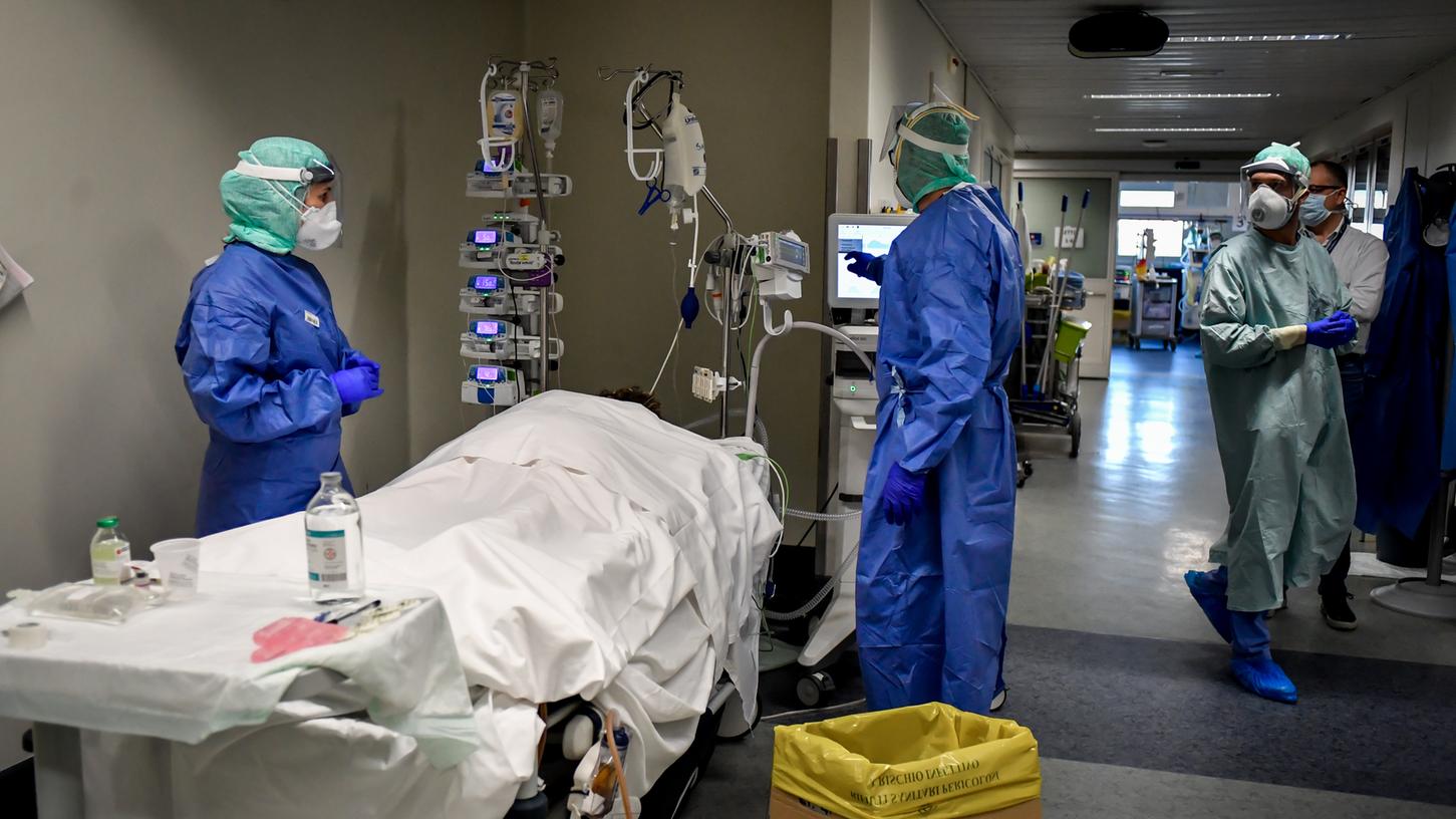 Medizinisches Personal behandelt am Gang der Intensivstation des Krankenhauses von Brescia einen Patienten. Die Krankenhäuser in der Lombardei sind gnadenlos überfüllt.