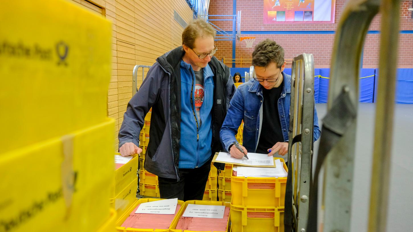 In der Turnhalle der Bert-Brecht-Schule haben Wahlhelfer am 29. März kistenweise Wahlscheine sortiert.