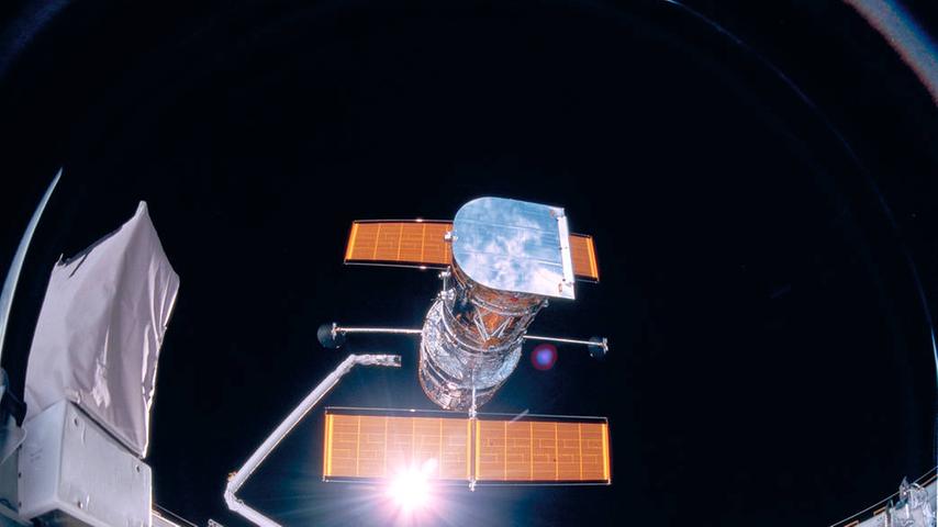 Vorsichtig setzt der Greifarm der Discovery das Teleskop Hubble, das so groß ist wie ein Schulbus, im Weltraum aus. Dann entfernt sich das Raumschiff vorsichtig, um mit seinen Abgasen die Optik nicht zu verschmutzen.