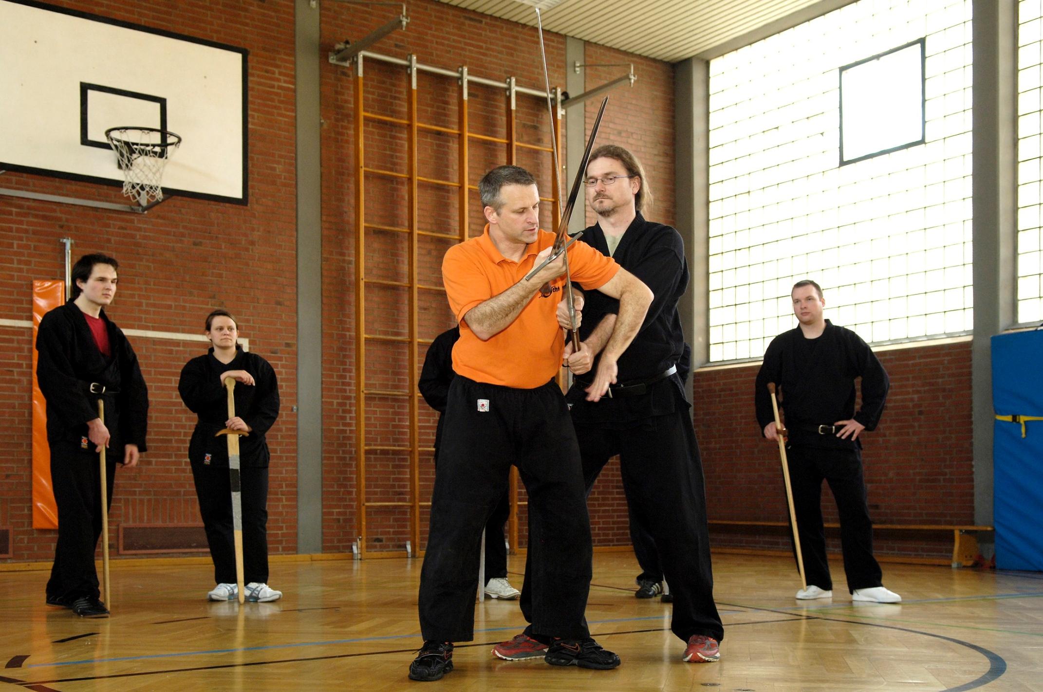 Die uralten Fechtbücher, mit denen Trainer Hans Heim von der Schwertkampfschule Ochs arbeitet, bieten viel mehr als „nur“ Hiebe und Stiche: Hier zeigt Heim (orangenes Hemd) eine raffinierte Entwaffnungstechnik. 